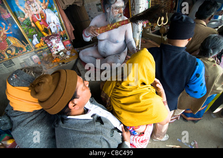 Un Naga Sadhu bénit les pèlerins se rendant sur le Gangasagar mela au Bengale occidental, en Inde. Banque D'Images