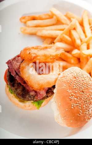 Sandwich hamburger américain classique avec des oignons et de frites, plus de délicieux mets sur portfolio Banque D'Images