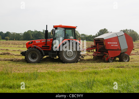 Presse à foin circulaire et du tracteur. Banque D'Images