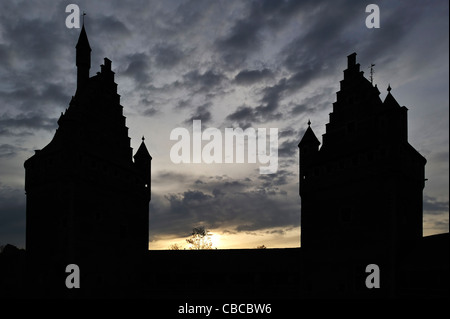 La silhouette sombre au toit étape tours et tourelles de la cité médiévale du château de Beersel, Belgique, au coucher du soleil Banque D'Images