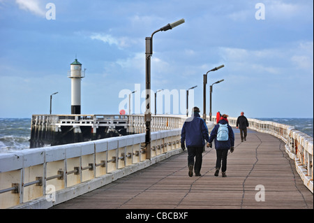 Les touristes marche sur jetée en bois pendant un temps orageux, Nieuwpoort, Belgique Banque D'Images