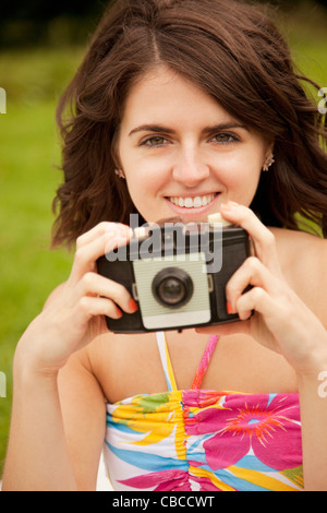 Woman taking pictures in park Banque D'Images