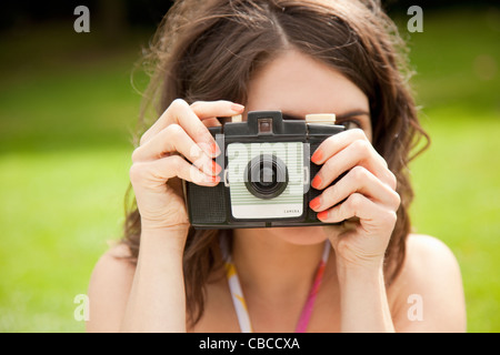 Woman taking pictures in park Banque D'Images