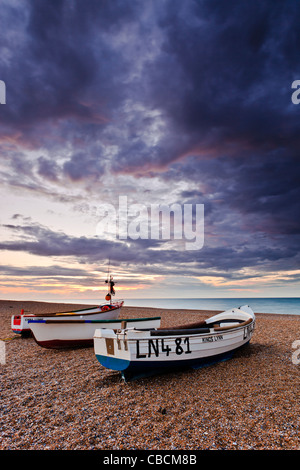 Trois petits bateaux de pêche sur la plage de galets du Claj suivant la mer sur la côte nord du comté de Norfolk Banque D'Images