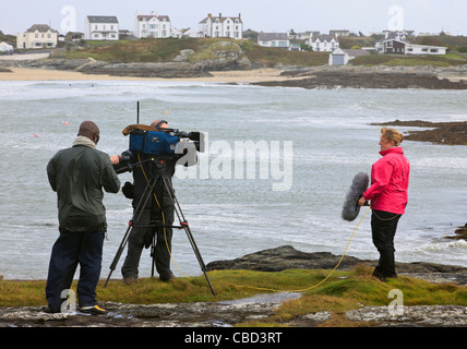 UK BBC live news reporter et l'équipage de l'appareil photo avec un coup de vent sur coup de vent sur la côte ouest du pays de Galles. Banque D'Images