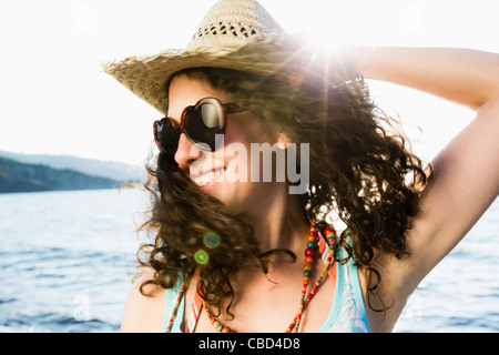 Woman in straw hat smiling on beach Banque D'Images