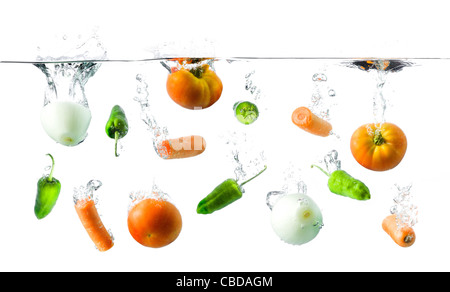 Un des légumes frais tomber dans une casserole remplie d'eau Banque D'Images