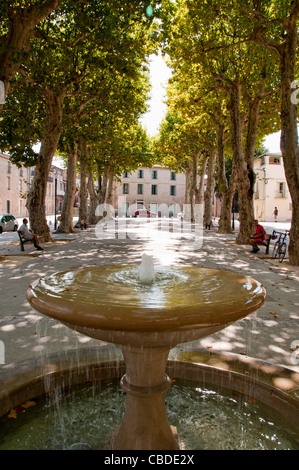 Une fontaine dans un square bordé d'arbres à Gignac Hérault Languedoc-Roussillon France Banque D'Images