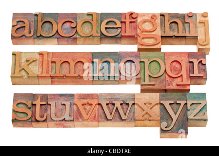 Compléter l'alphabet (minuscules) dans les blocs de la typographie en bois vintage tachés par les encres couleur, isolated on white Banque D'Images