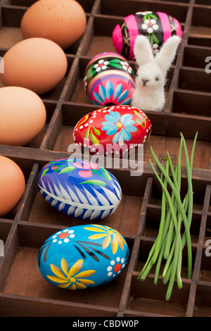 Concept de décoration de Pâques - brown les oeufs de poule, oeufs peints avec motif floral, vert et ciboulette lapin en laine Banque D'Images