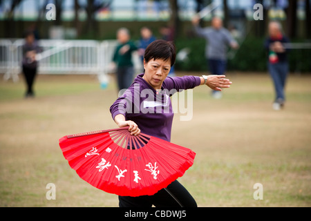 Mature Woman practicing Tai Chi dans le parc Victoria, Causeway Bay, Hong Kong, Chine Banque D'Images