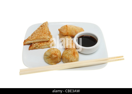 En-cas chinois crevettes rôties, crêpes, pains, wonton et un bol de sauce de soja sur une assiette avec des baguettes Banque D'Images