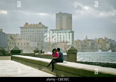 Jeune couple assis sur le mur d'El Malecon Cuba La Havane Banque D'Images