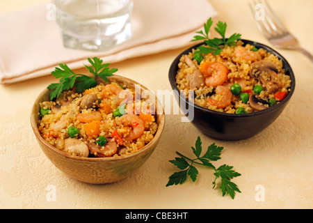 Couscous aux crevettes et champignons. Recette disponible. Banque D'Images