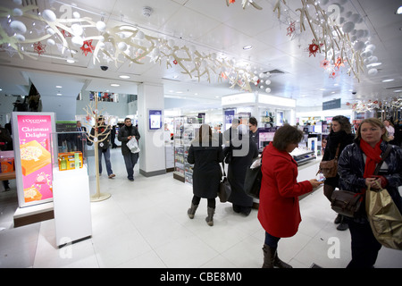 Clients dans la section parfum de grand magasin John Lewis Oxford street Christmas shopping Londres Angleterre Royaume-Uni uk Banque D'Images