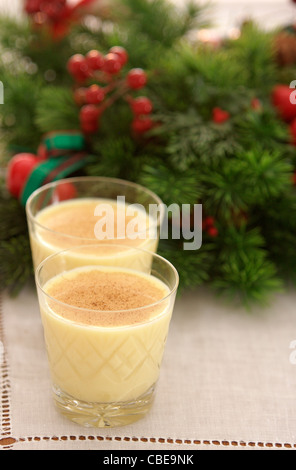 Deux verres de lait garnie de muscade sont alignées en face d'une couronne de Noël Décoration Banque D'Images