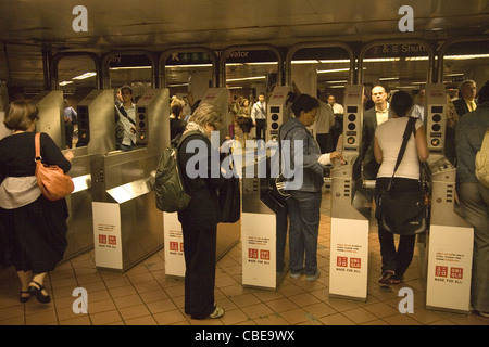 Les banlieusards passent par les tourniquets au Grand Central Station de métro à New York. Banque D'Images