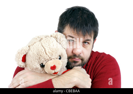 Contradiction : grand homme barbu d'âge moyen difficile giveing un gros câlin à un soft et mignon ours en peluche. Banque D'Images