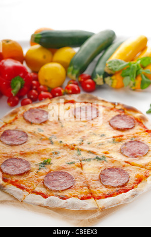 D'origine italienne pizza au pepperoni à croûte mince avec des légumes frais en arrière-plan Banque D'Images