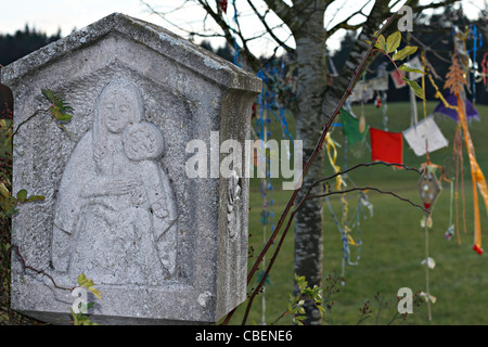 Marie Chistian Wayside culte avec les drapeaux de prière bouddhiste suspendu à des branches d'arbre, Chiemgau Haute-bavière Allemagne Banque D'Images