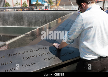 Un visiteur lit les noms au Mémorial National du 11 septembre à New York. Banque D'Images