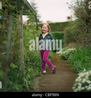 Petite fille debout dans le jardin Banque D'Images