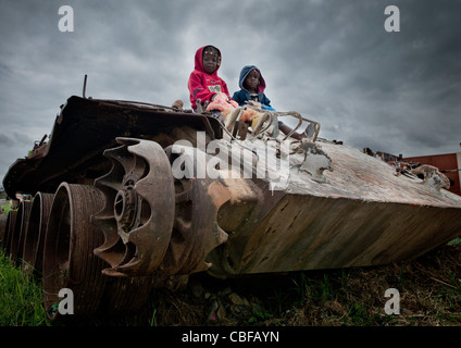 Les enfants sur une épave du réservoir de la guerre civile, l'Angola Banque D'Images