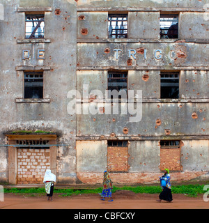 Les femmes en face de la façade criblée de balles de Empreza Frabrica de Angola, Kuito, Angola Banque D'Images