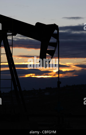 Pompe à huile sur un puits de pétrole sur le champ pétrolifère de Midway-Sunset près de Taft, Californie à l'aube. Banque D'Images