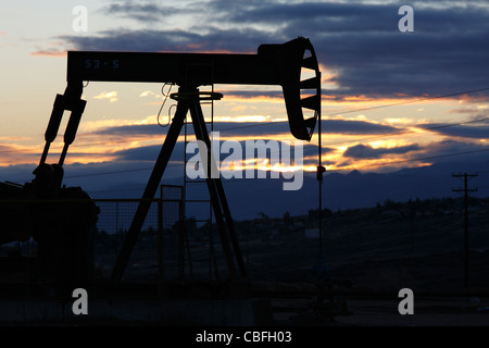 Pompe à huile sur un puits de pétrole sur le champ pétrolifère de Midway-Sunset près de Taft, Californie à l'aube. Banque D'Images