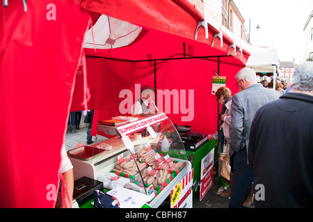 Marché Victorien Louth Lincolnshire, Angleterre, vendeur de saucisses avec les consommateurs à la recherche d'acheter de la viande Banque D'Images