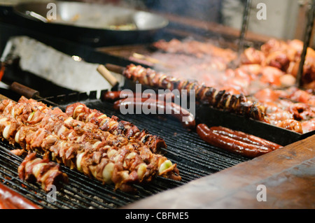 Brochettes brochettes de saucisses, jambon et knuckles en vente au marché de Noël, Cracovie Banque D'Images