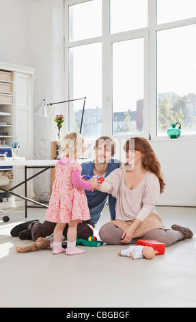 Une jeune fille et ses parents jouer avec des jouets Banque D'Images