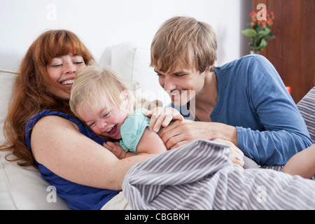 Une jeune famille ludique ayant in bed Banque D'Images