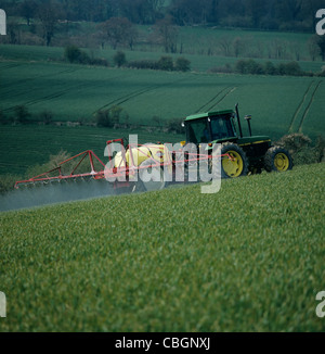 Tracteur John Deere et la pulvérisation Pulvérisateur traîné Hardi dans la récolte de blé de printemps Banque D'Images