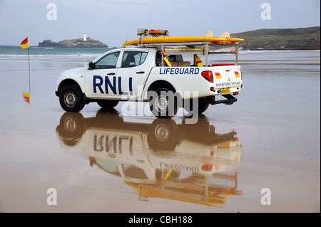 Un sauveteur RNLI sauvetage du chariot avec une planche de surf sur une plage de sable. Les véhicules de sauvetage avec du sable et de la mer. Banque D'Images