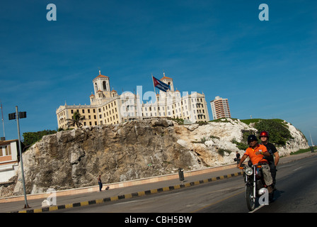 Cuba, La Havane, l'hôtel Nationale, moto, en passant par les drapeaux cubains Banque D'Images