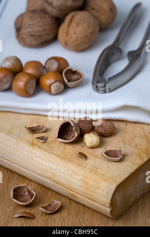 Les noisettes et les noix sur une planche à découper à l'aide de l'écrou de craquelins et de noix Banque D'Images