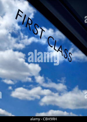 Voyages en première classe signer sur la fenêtre de fer Pullman train avec l'infini ciel bleu et nuages derrière concept des transports de générique Banque D'Images