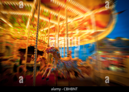 Carousel horses with motion blur sur un manège éclairé, Brighton, UK Banque D'Images