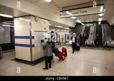 Les touristes consulting carte tube à la station de métro d'Heathrow de Londres Angleterre Royaume-Uni uk Banque D'Images