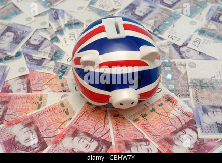 Union Jack Tirelire avec un ventilateur de 50 et 20 livres de billets de banque pour représenter la crise de la dette. Banque D'Images