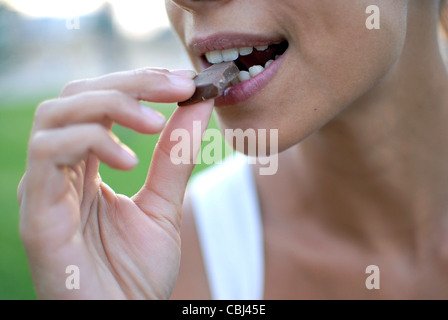 Young woman eating chocolate Banque D'Images