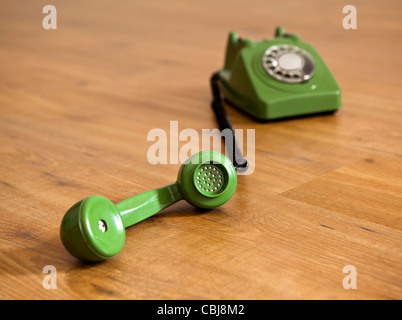 Téléphone vert Vintage sur un plancher de bois Banque D'Images