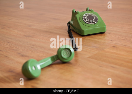 Téléphone vert Vintage sur un plancher de bois Banque D'Images