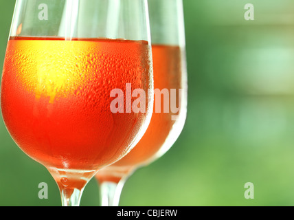 Deux verres d'un vin rose contre un arrière-plan vert Banque D'Images