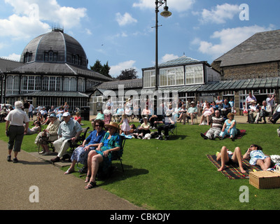 Des foules de gens se détendre et profiter de l'été la météo à Buxton pavilion gardens dans la campagne du Derbyshire en Angleterre Banque D'Images