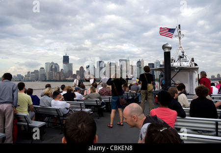 Voyageurs sur pont supérieur du Ferry de retour à Manhattan après le voyage de Statue de la Liberté et Ellis Island à New York Harbor Banque D'Images