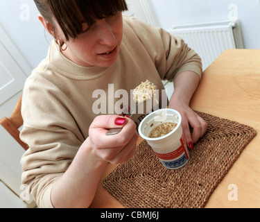 Woman Eating Instant Poulet et nouilles aux Champignons dans un pot Banque D'Images