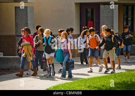 Un groupe multiethnique de Californie middle school cross leur campus entre les classes. Banque D'Images